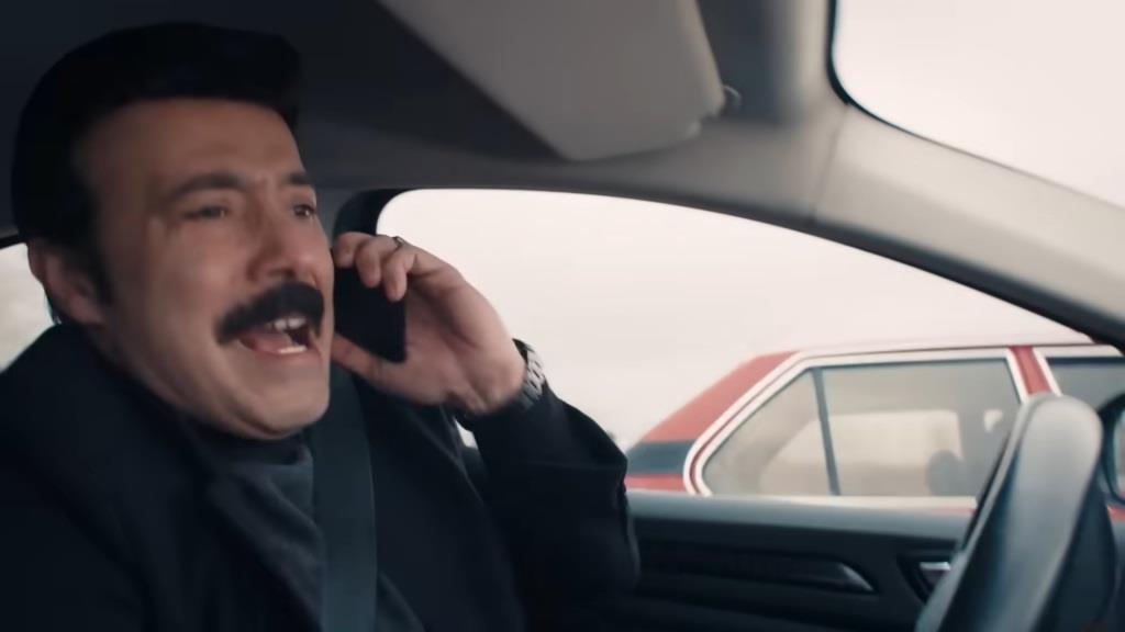 Nedim krzyczy do telefonu prowadząc samochód.