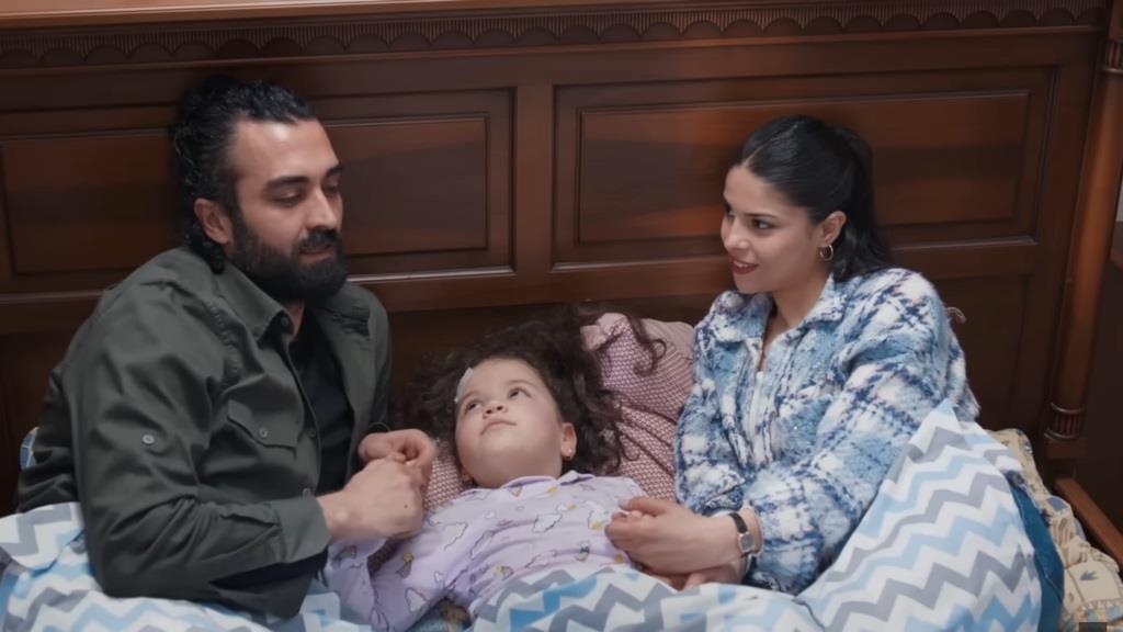 Ferit i Ayse leżą w łóżku z Dogą.