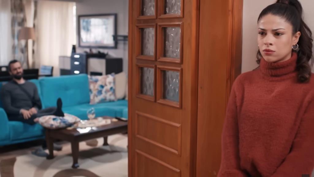 Ayse podsłuchuje monolog Ferita, stojąc przy wejściu do pokoju dziennego.