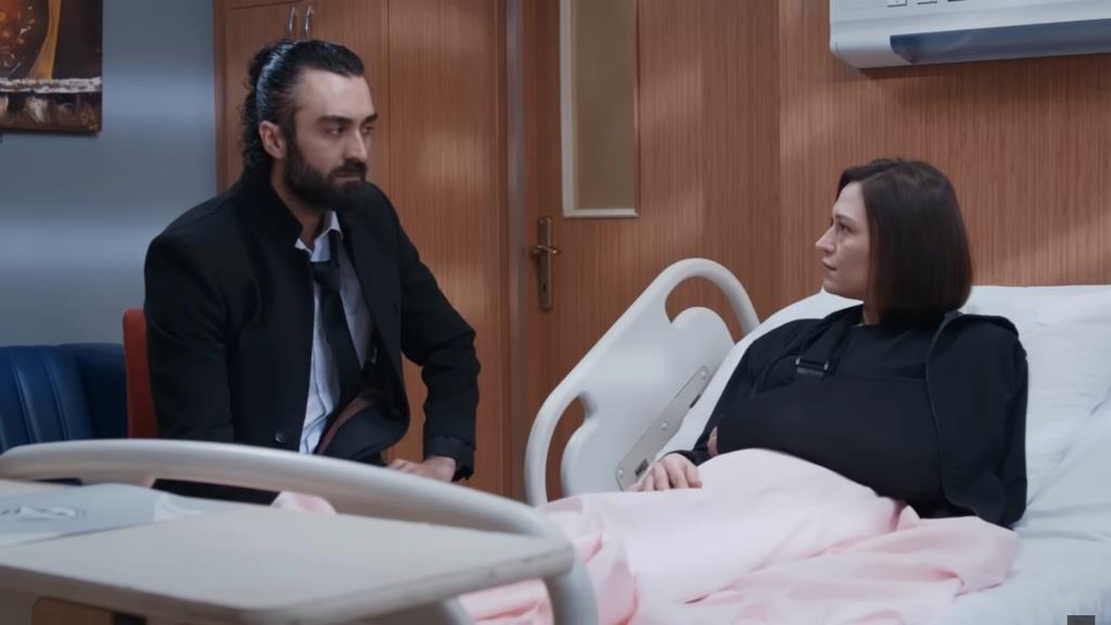 Akasya leży na szpitalnym łóżku. Obok siedzi Ferit.