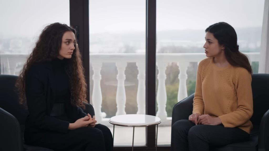 Nana i Pinar rozmawiają, siedząc naprzeciwko siebie w fotelach.