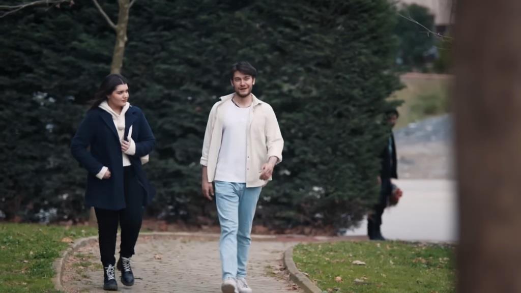 Nese i Timur idą alejką. W tle widać wyglądającego zza iglaków Volkana.