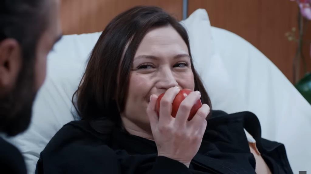 Akasya konsumuje jabłko, śmiejąc się przy tym.