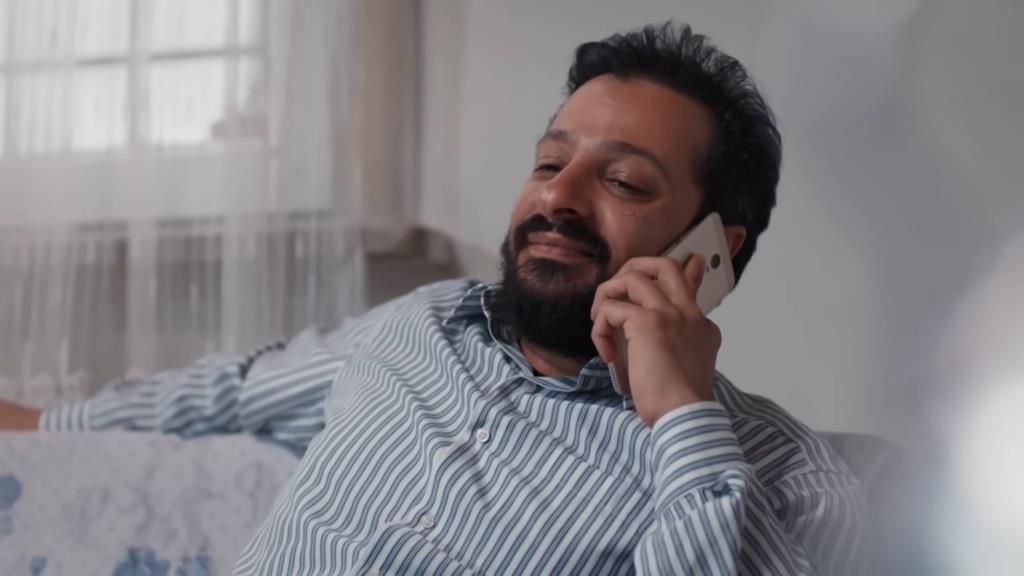 Idris trzyma telefon przy uchu.