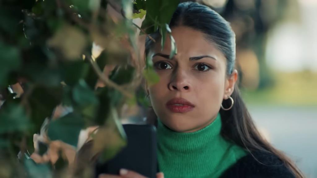 Ayse ukrywa się za zaroślami.