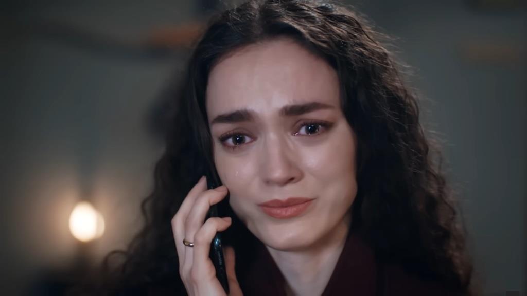 Nana rozmawia przez telefon. Jej oczy pełne są łez.