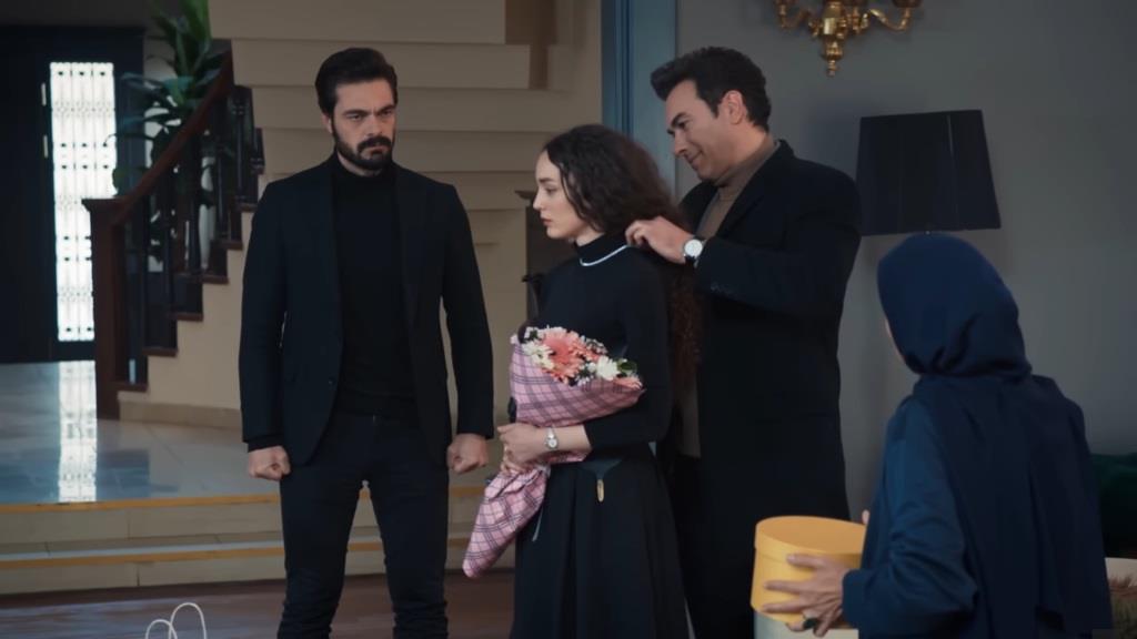 Nedim zakłada na szyję Nany naszyjnik. Yaman stoi obok i przygląda się temu.