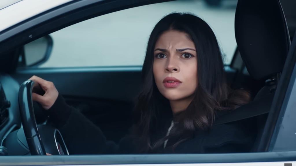 Ayse wygląda przez opuszczoną szybę.