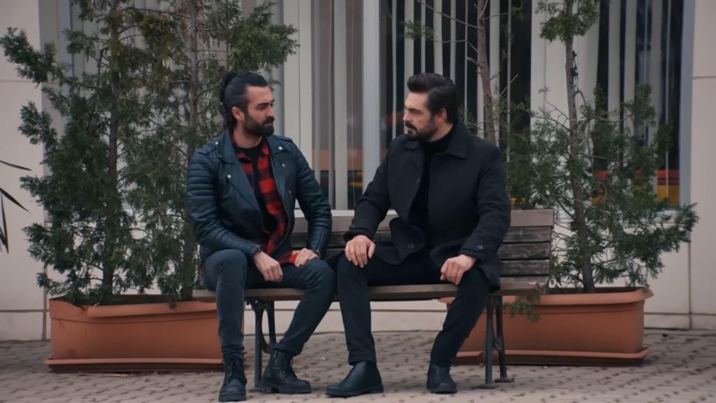 Ferit i Yaman siedzą na ławce przed szpitalem.