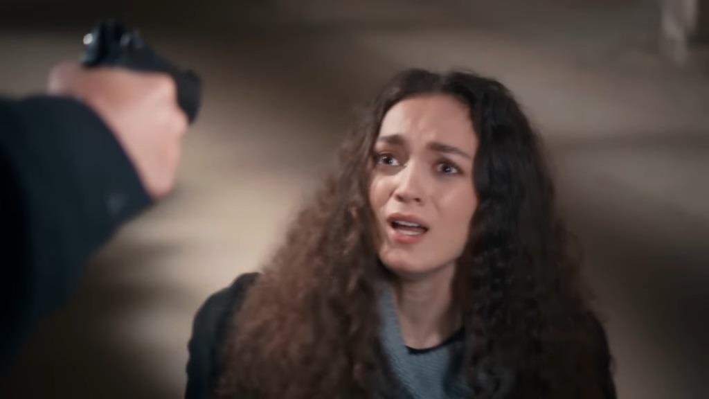 Nana jest przerażona, widząc wycelowaną w siebie broń.