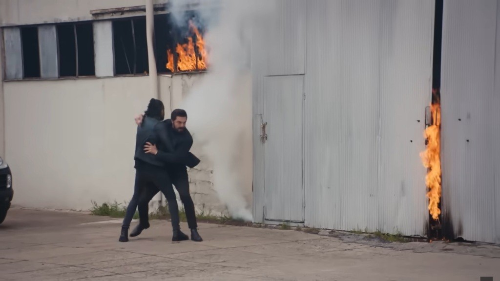 Ferit powstrzymuje Yaman przed wejściem do ogarniętego pożarem magazynu.