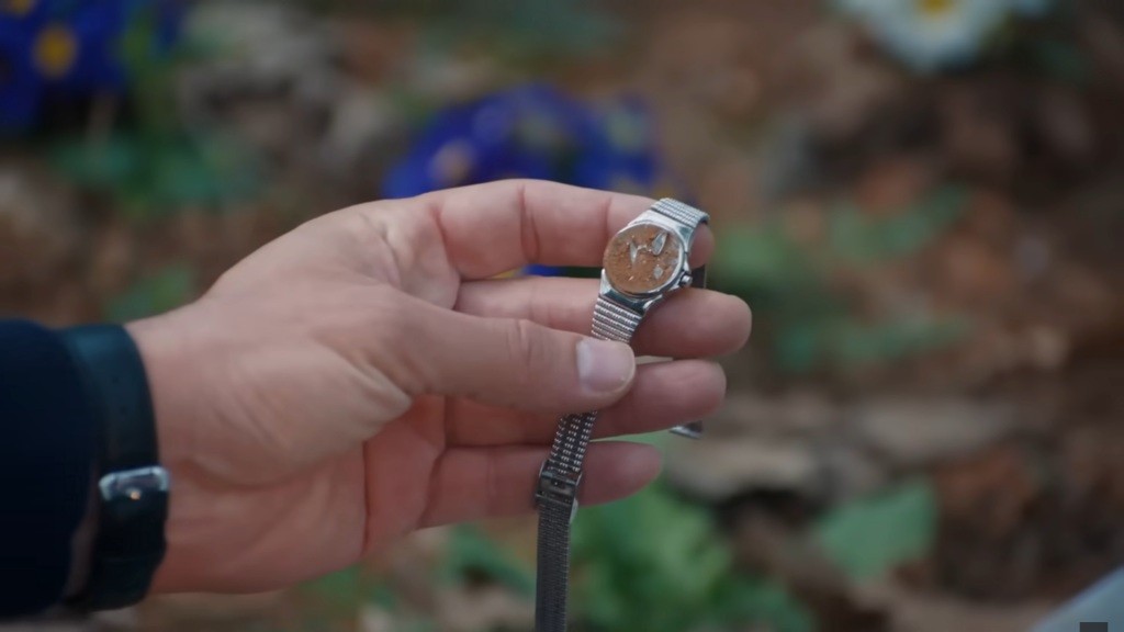 Yaman trzyma w ręku pokryty ziemią zegarek Nany.