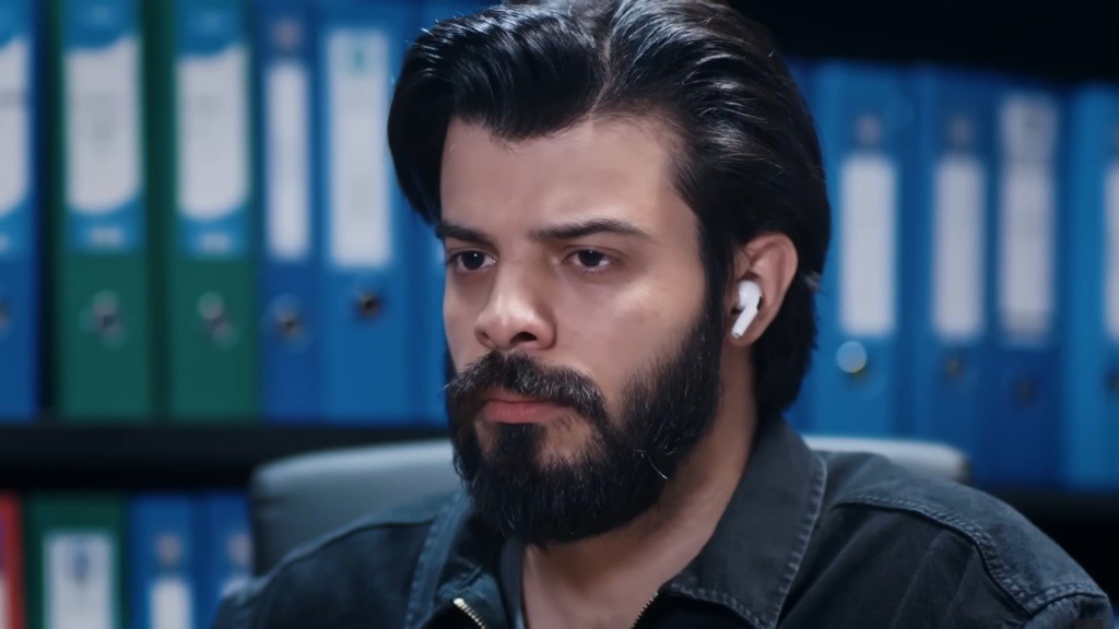 Volkan ze słuchawką w uchu.