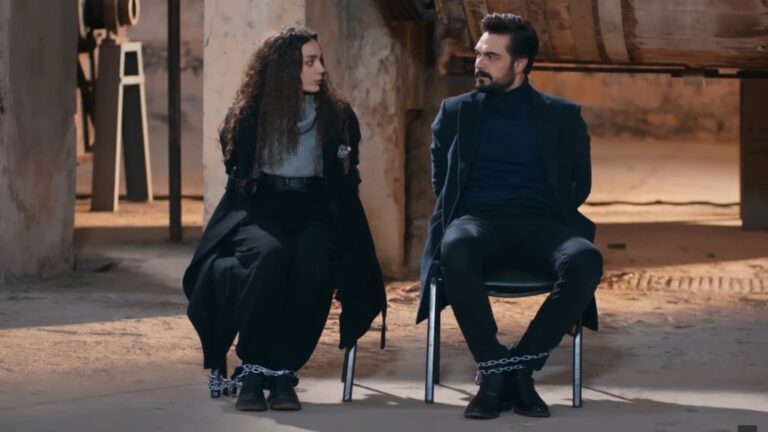 Kadr przedstawia Nanę i Yamana w magazynie. Są przykuci łańcuchami do krzeseł.