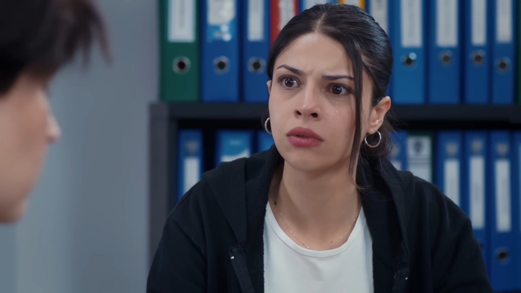 Ayse jest zdruzgotana. Po jej lewej powiece spływa łza.