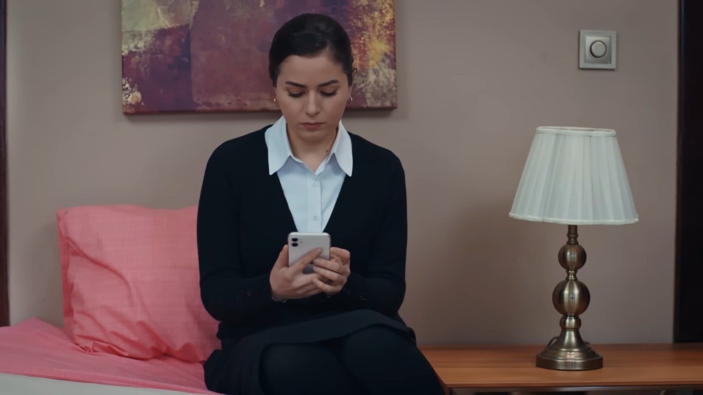 Aynur trzyma w rękach telefon.