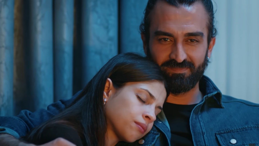 Ferit uśmiecha się, podczas gdy Ayse śpi na jego ramieniu.