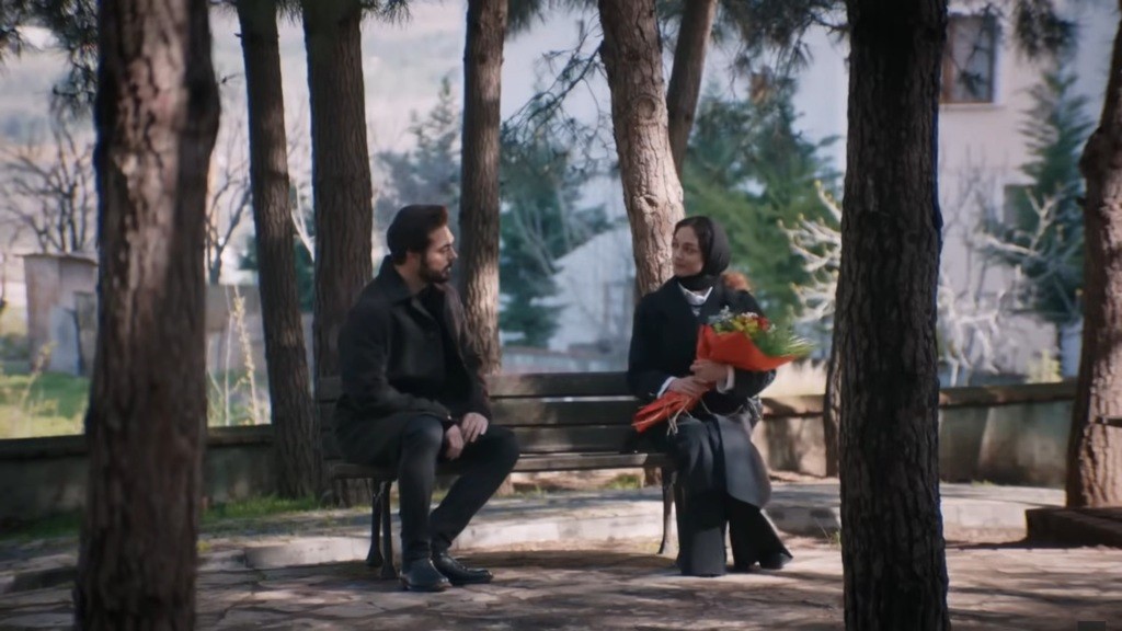 Nana i Yaman siedzą na ławce podczas randki w parku.