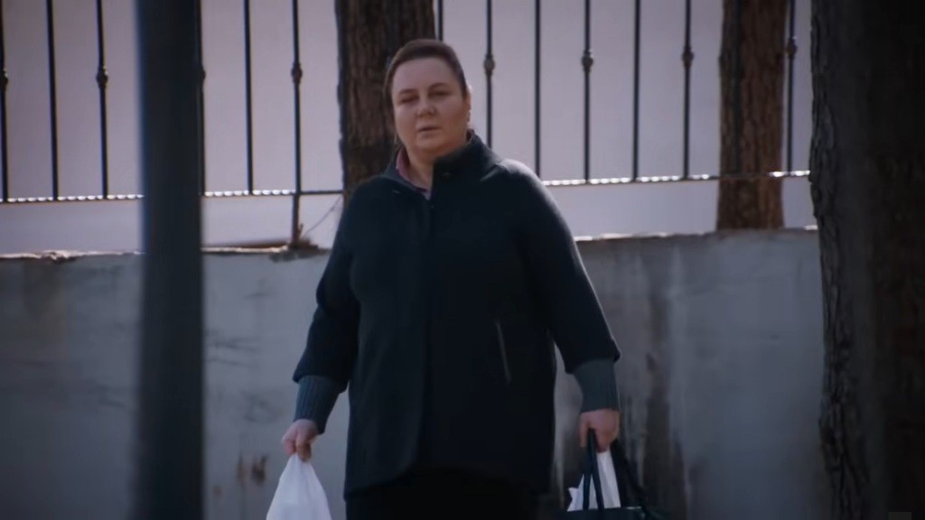 Adalet niesie siatki z zakupami.