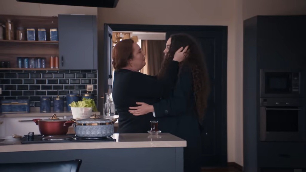 Adalet stoi przed Naną i obejmuje ją.