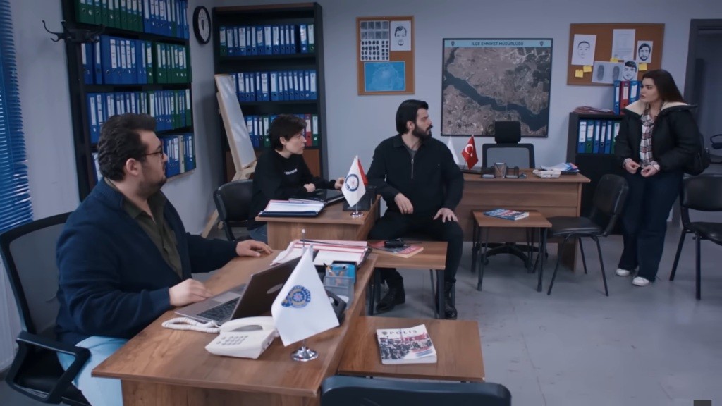 Nese wchodzi do biura na komisariacie.