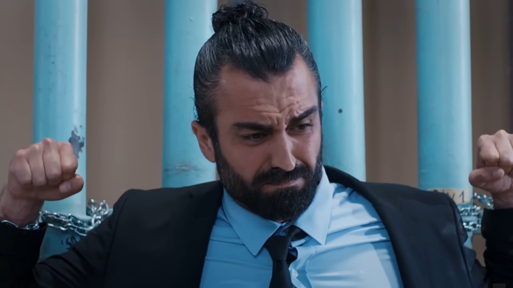 Ferit walczy z krępującymi go łańcuchami, chcąc pomóc Ayse.