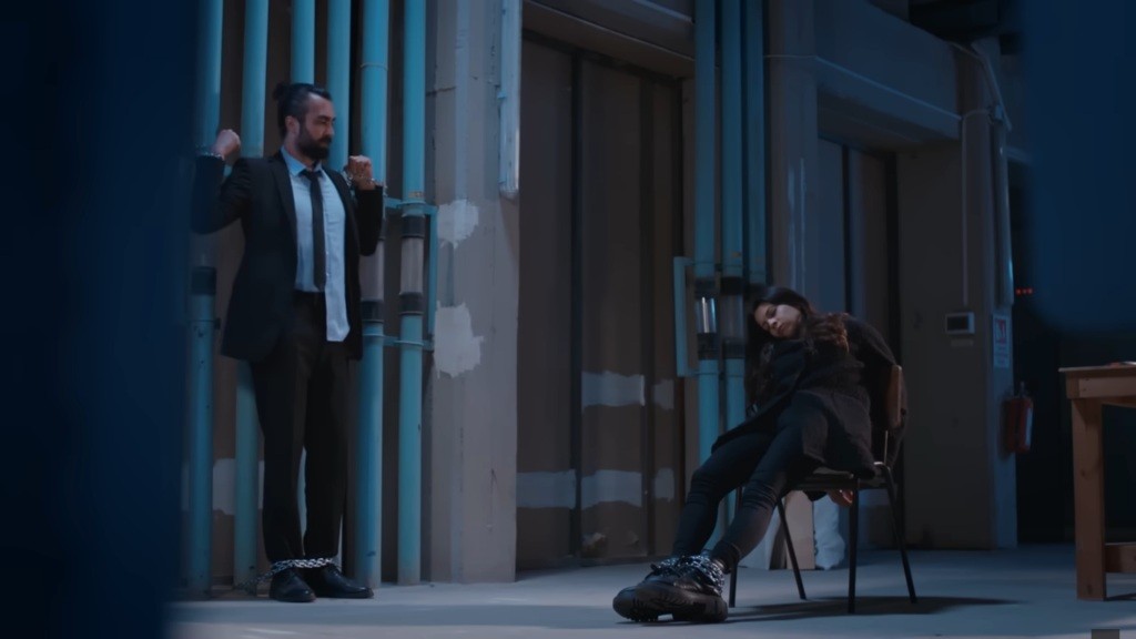 Scena w magazynie. Ayse po podaniu trucizny jest nieprzytomna. Ferit jest przykuty łańcuchami do rur.