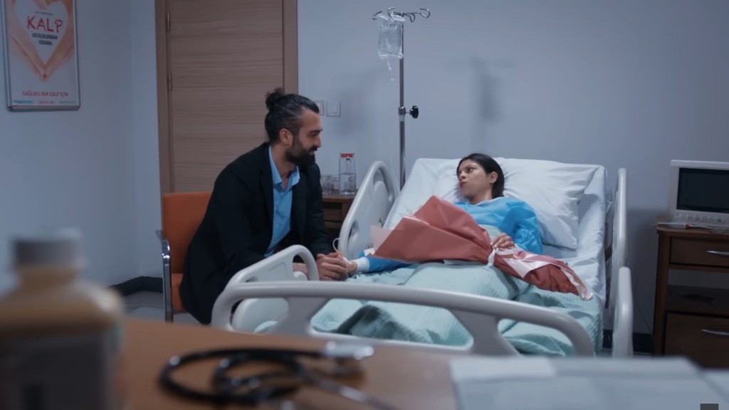 Ferit rozmawia z Ayse, leżącą na szpitalnym łóżku.