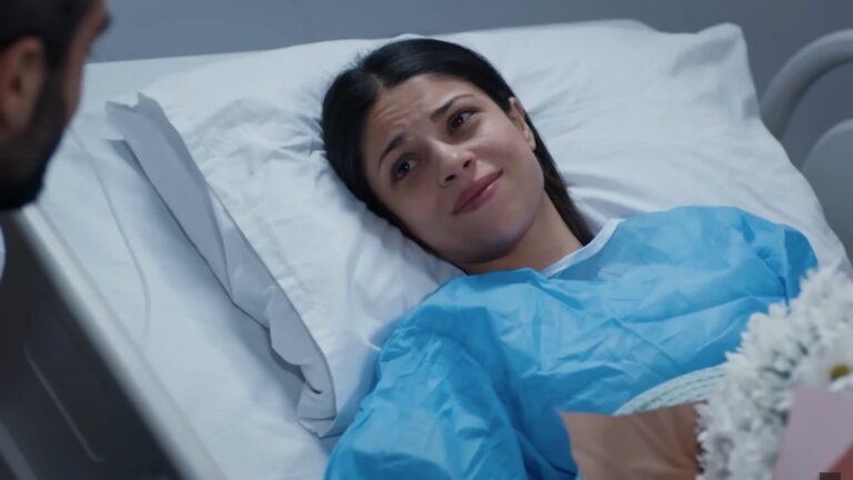 Ayse uśmiecha się, leżąc na szpitalnym łóżku. W rogu zdjęcia widać stokrotki, które podarował jej Ferit.