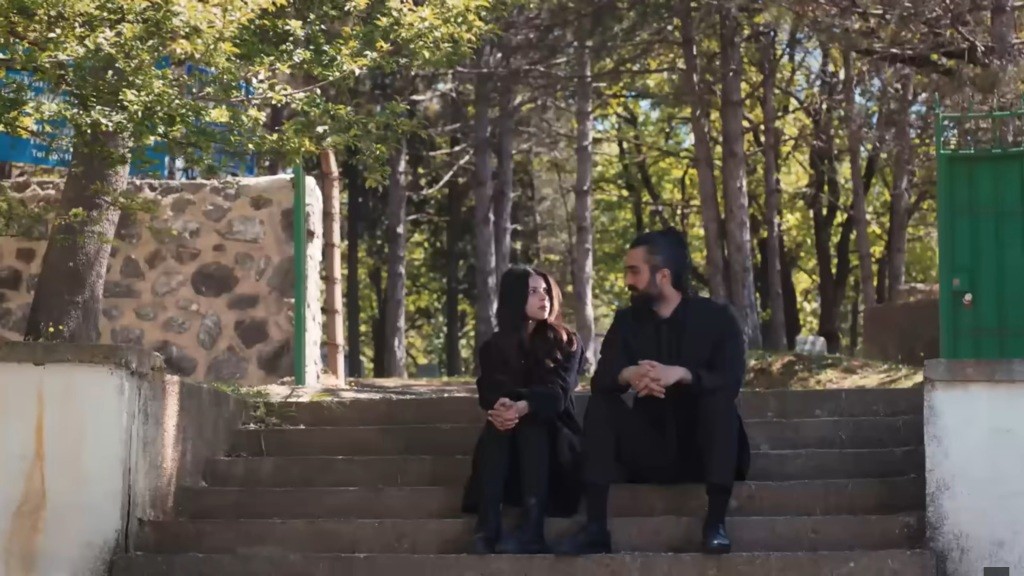 Ayse i Ferit siedzą na schodach.