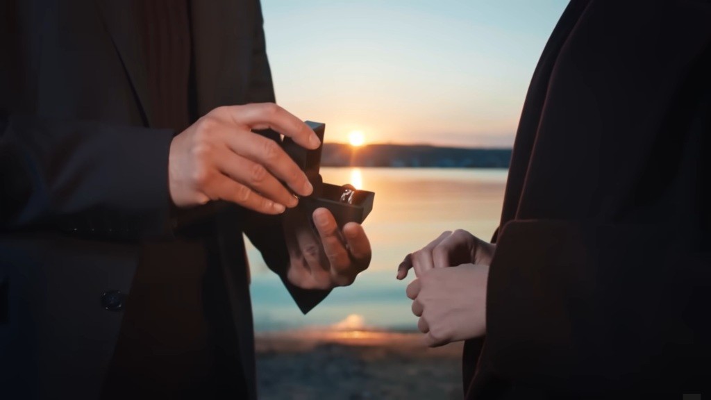 Zbliżenie na pudełeczko z pierścionkiem w rękach Yamana.