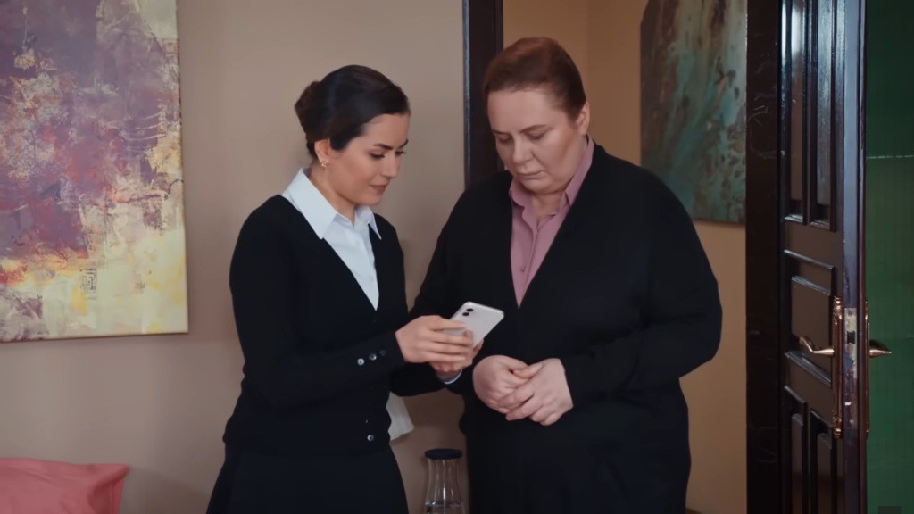 Aynur pokazuje Adalet zdjęcie Idrisa na telefonie.