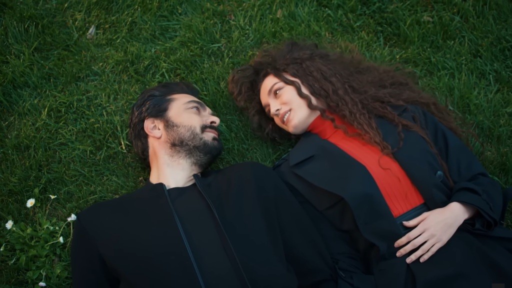 Yaman i Nana leżą na trawie wpatrzeni w siebie.