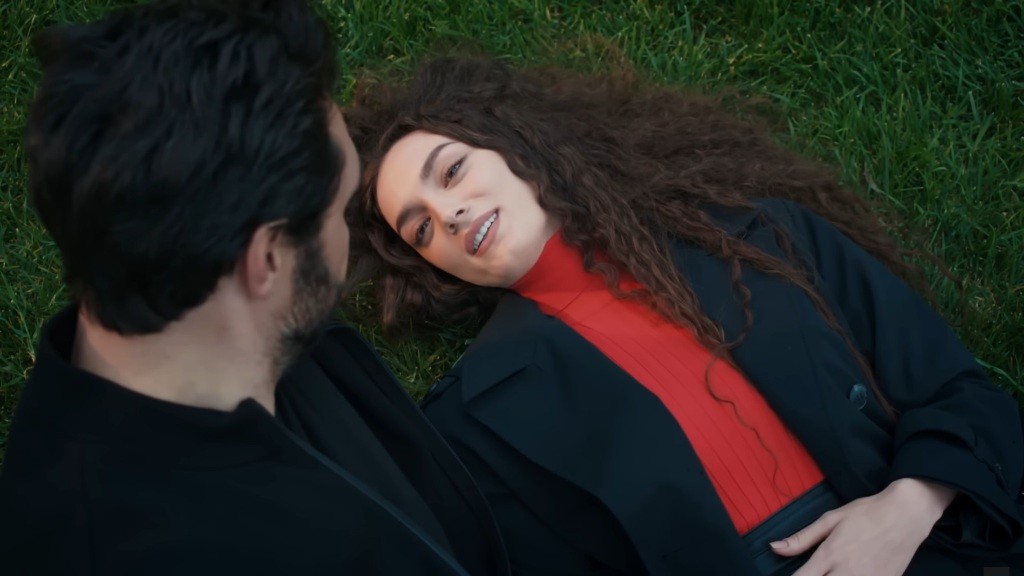 Yaman pochyla się nad leżącą na trawie Naną.