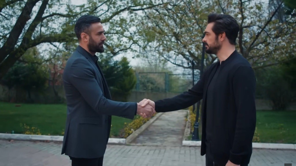 Acar i Yaman wymieniają się uściskiem dłoni.