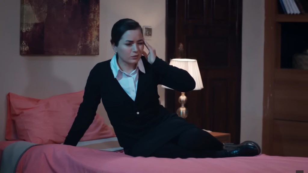 Aynur budzi się z bólem głowy.