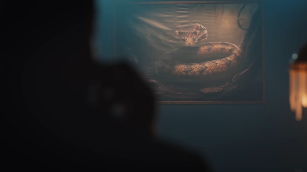 Pomieszczenie, w którym przebywa mafioso Trucizna. Kadr przedstawia obraz węża wiszący na ścianie.