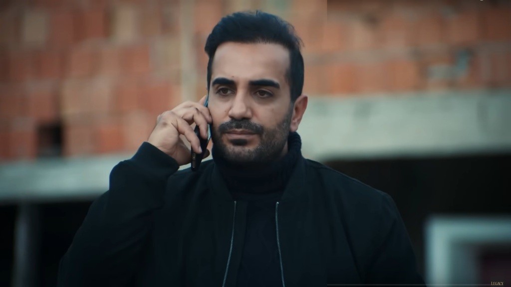 Kazim rozmawia przez telefon.