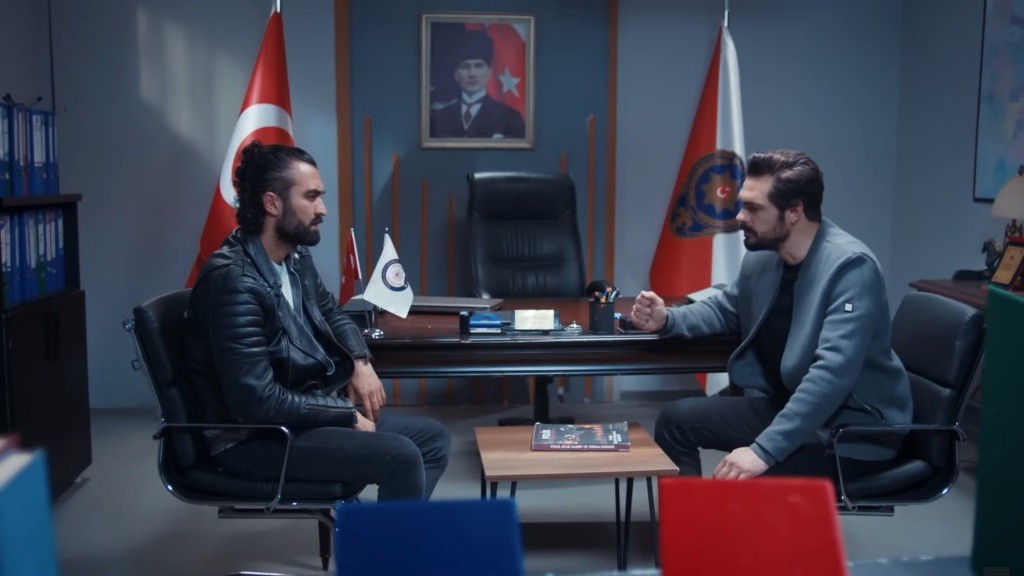 Ferit rozmawia z Yamanem w swoim gabinecie na komisariacie.