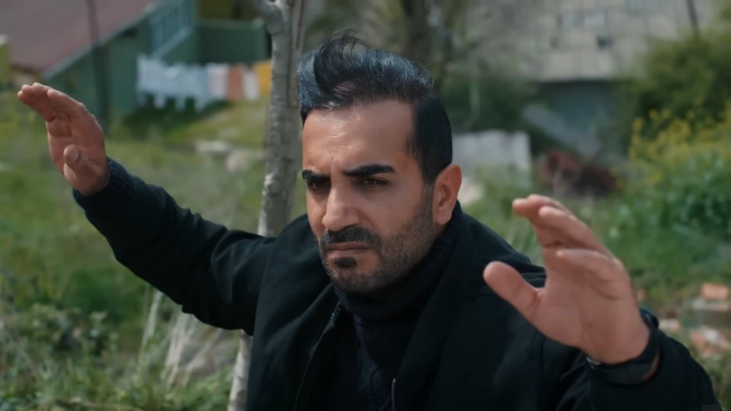 Kazim trzyma ręce w górze.