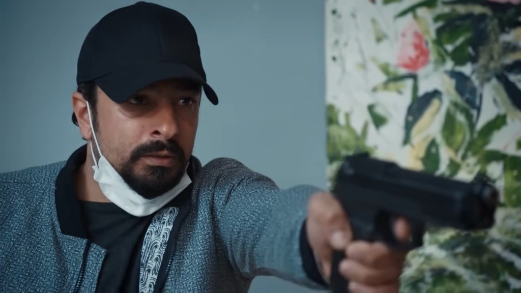 Idris mierzy do Yamana z broni.