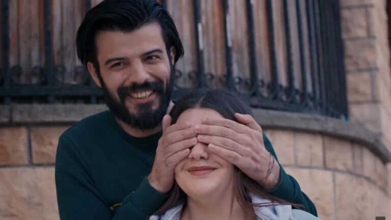 Volkan zakrywa oczy Nese dłońmi.