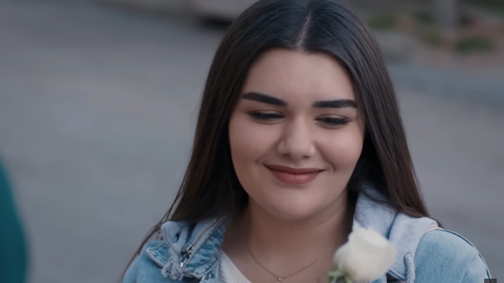 Nese uśmiecha się, patrząc na biały pąk.