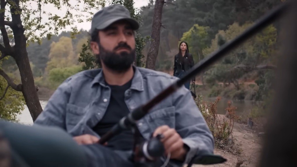 Ayse pojawia się za plecami łowiącego ryby Ferita.