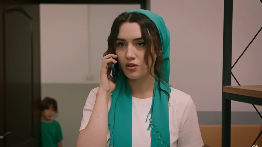 Zeynep rozmawia przez telefon na zapleczu.