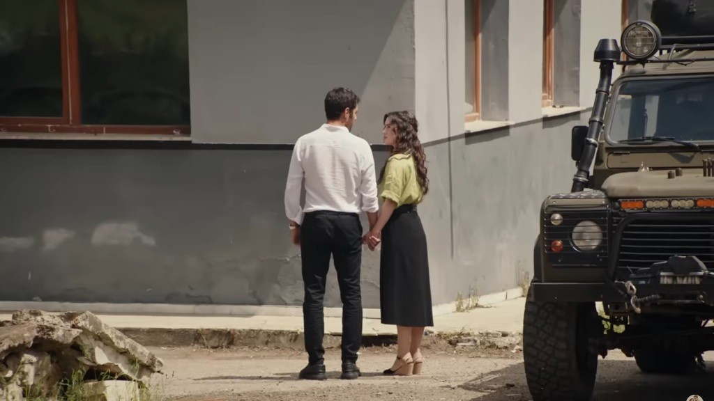 Halil i Zeynep trzymają się za ręce, patrząc na siebie.