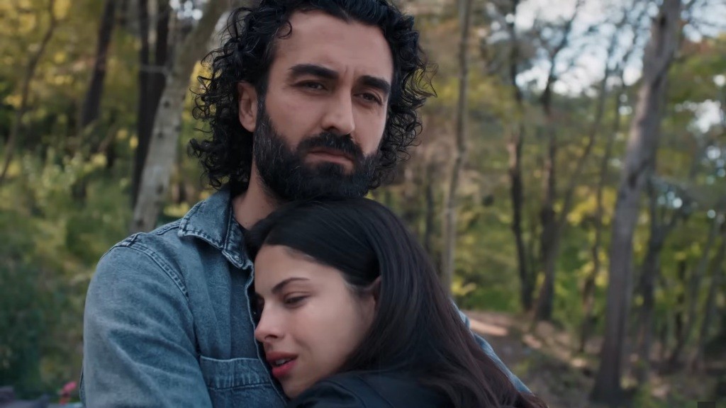 Zbliżenie na Ayse, która przytula głowę do piersi Ferita.