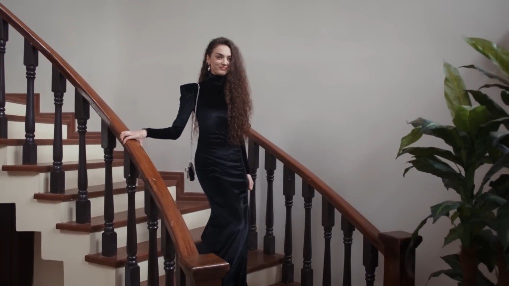 Elegancko ubrana Nana schodzi po schodach.