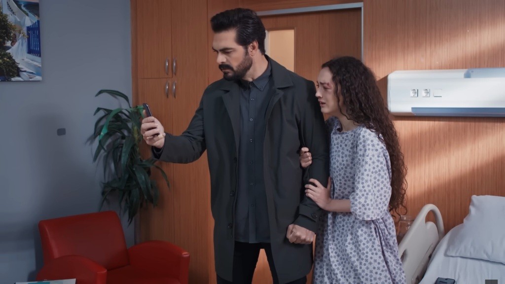 Yaman i Nana wpatrują się w ekran telefonu. Nana ujmuje mężczyznę za ramię. Na jej twarzy rysuje się wyraz przerażenia.