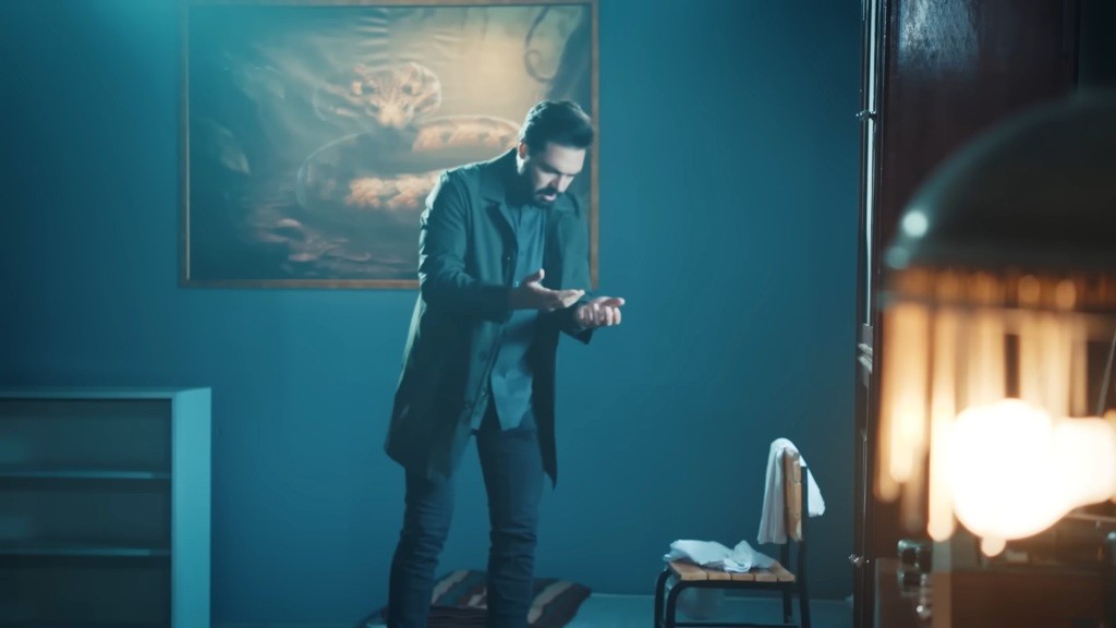 Yaman patrzy na swoje dłonie.